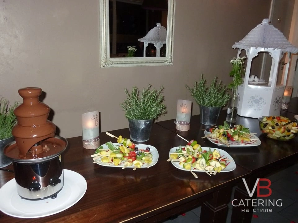 Фотография стола с шоколадным фонтаном и фруктовыми шпажками