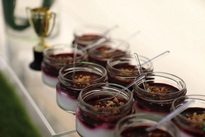 Фотография вкусных десертов поданных в баночках приготовленных профессиональной кейтеринговой компанией