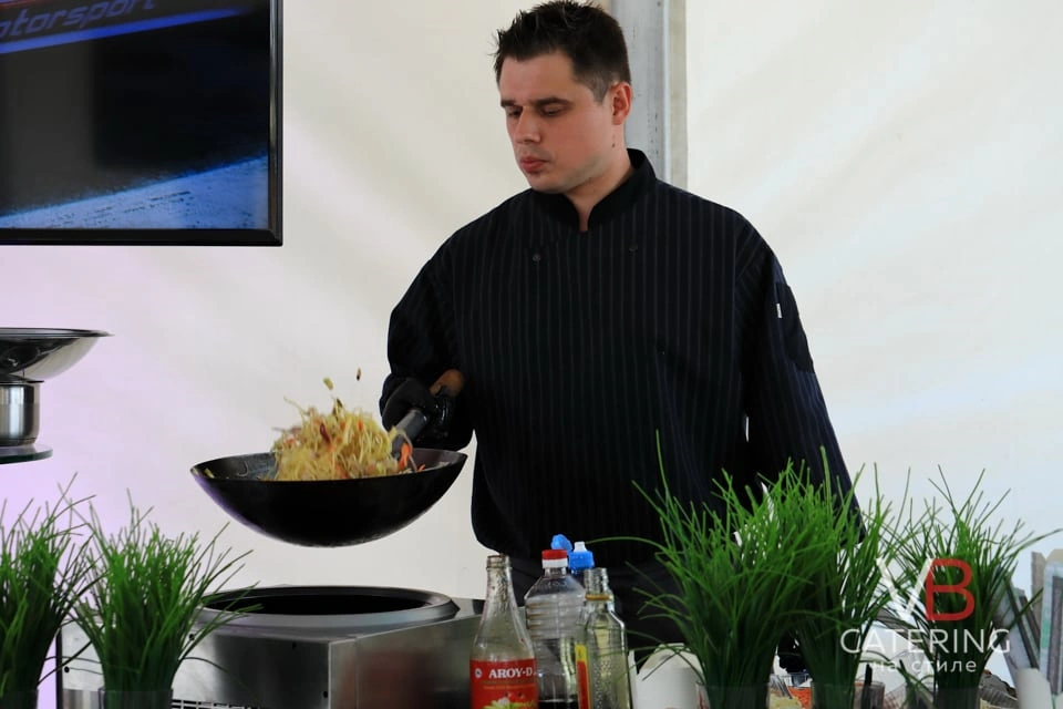 Фотография повара кейтеринга готовящего блюда на месте проведения мероприятия