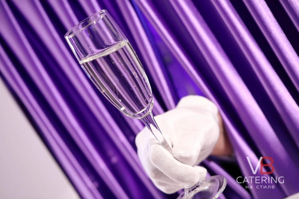 Фотография декора для мероприятия в виде руки с бокалом шампанского