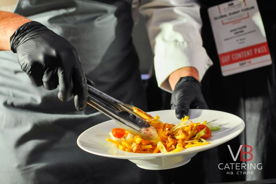 Фотография рук шеф-повара кейтеринга с тарелкой